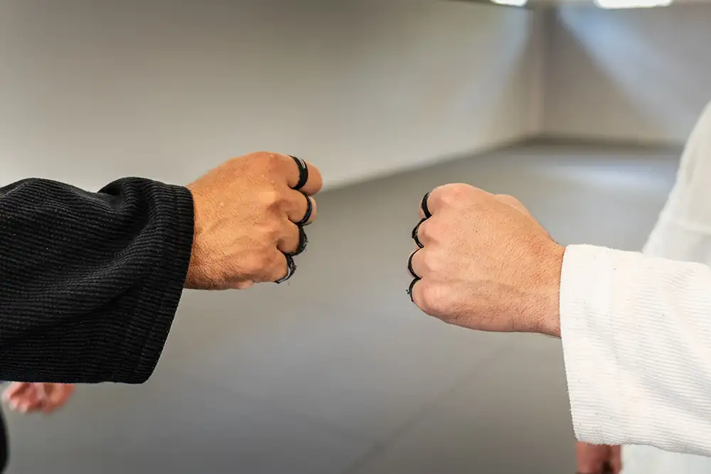 2 jiu jitsu students bumping fists as they celebrate the results of jiu jitsu marketing